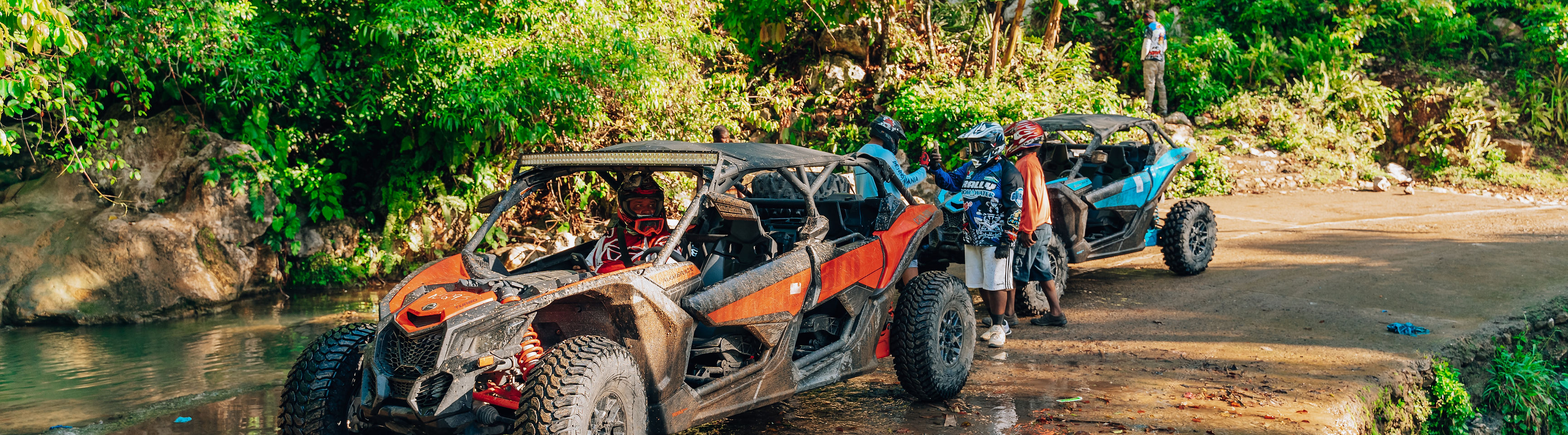 Avivaa UTV tour group stopped by a river in the Haitian mountains